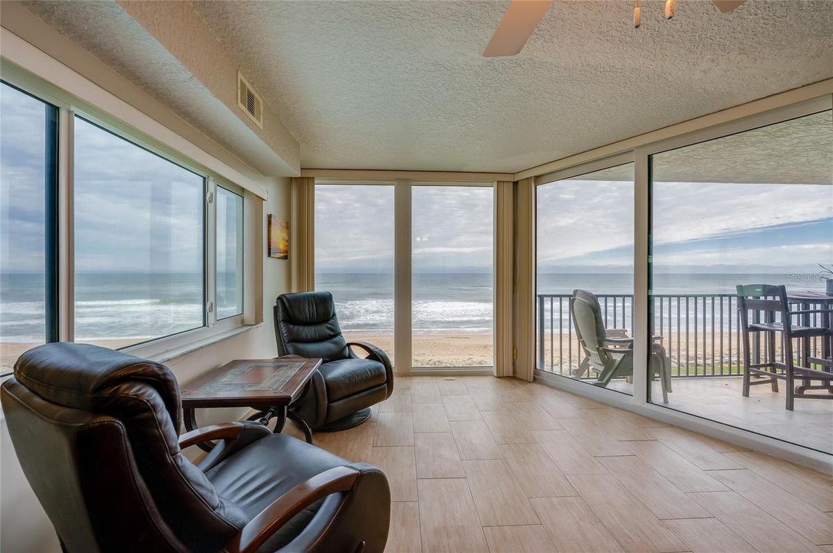 A light-filled corner retreat with panoramic ocean views through wraparound windows. This flexible space is perfect for morning coffee, reading, or en
