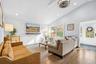 Living area with wood walls, recessed lighting, wood-type flooring, and high vaulted ceiling