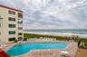 The oceanfront pool area features ample seating, a paved sun deck, and gated access to the beach—designed for relaxing and recreation.