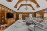 Living area with a high ceiling, arched walkways, built in features, wooden walls, and wood finished floors