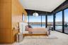 Carpeted bedroom with access to exterior, a water view, a wall of windows, and wooden walls