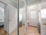 Doorway featuring radiator heating unit, tile patterned floors, crown molding, and ceiling fan