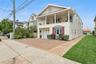 View of front of house with cooling unit, a balcony, a garage, and a front yard