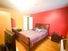 Bedroom with light wood-style flooring and heating unit