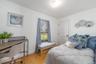 Bedroom with light wood-type flooring, baseboards, and an office area