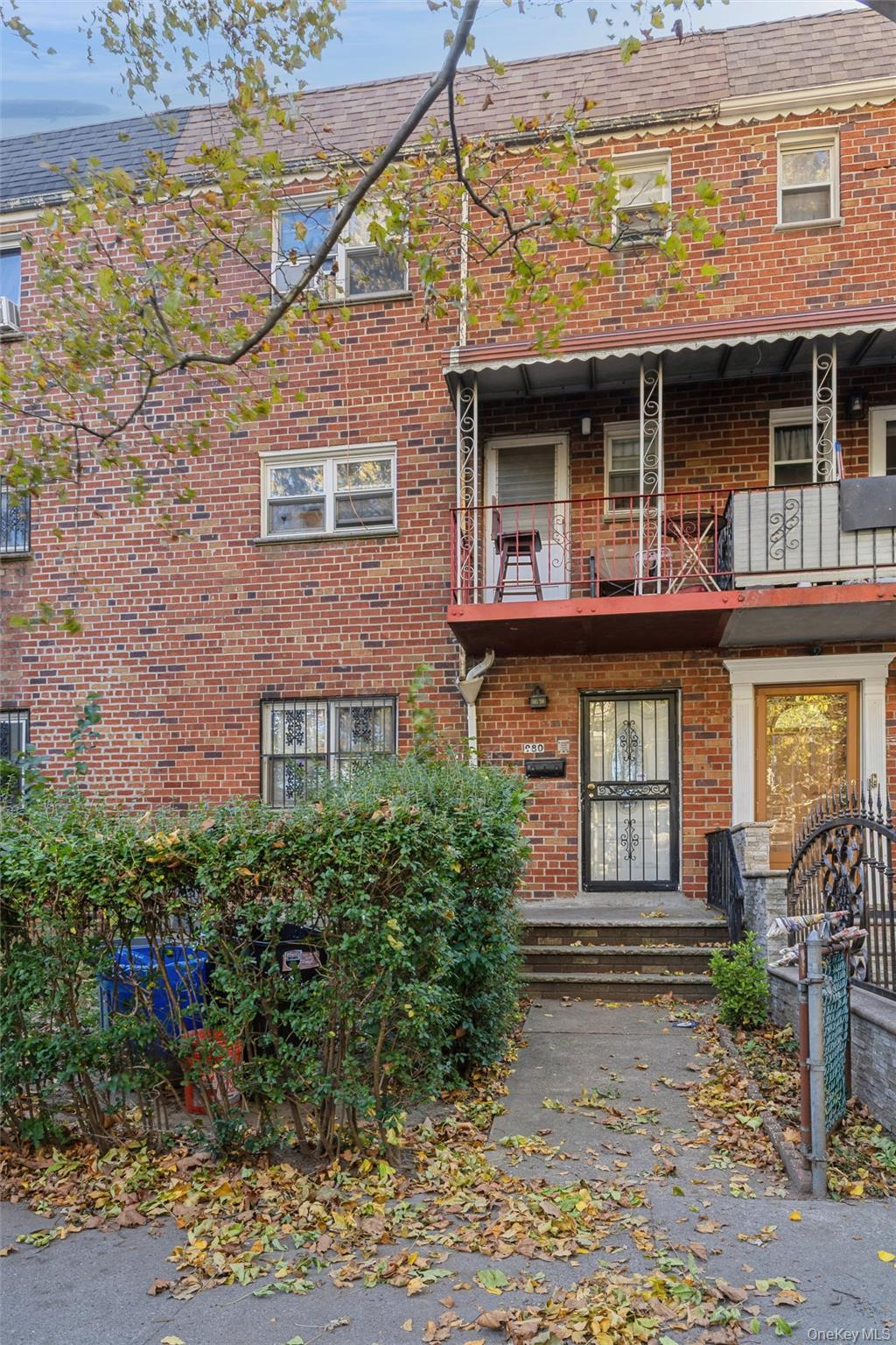 View of front of property with a balcony and brick siding