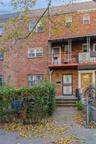 View of front of property with a balcony and brick siding