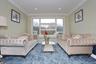 Living area with ornamental molding, radiator heating unit, and recessed lighting