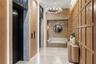 Elegant, hotel-inspired elevator lobby featuring warm wood paneling, integrated ambient lighting, polished stone floors and controlled-access elevator
