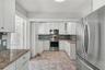 The expanded kitchen offers ample cabinetry, generous prep space, and the functionality needed for everyday living and entertaining.