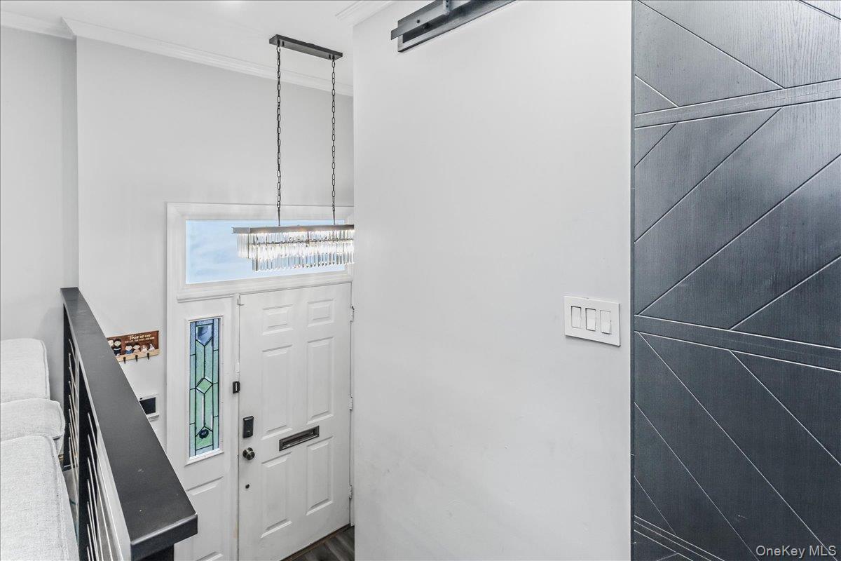 Entryway with a white paneled door featuring a stained glass sidelight and transom window