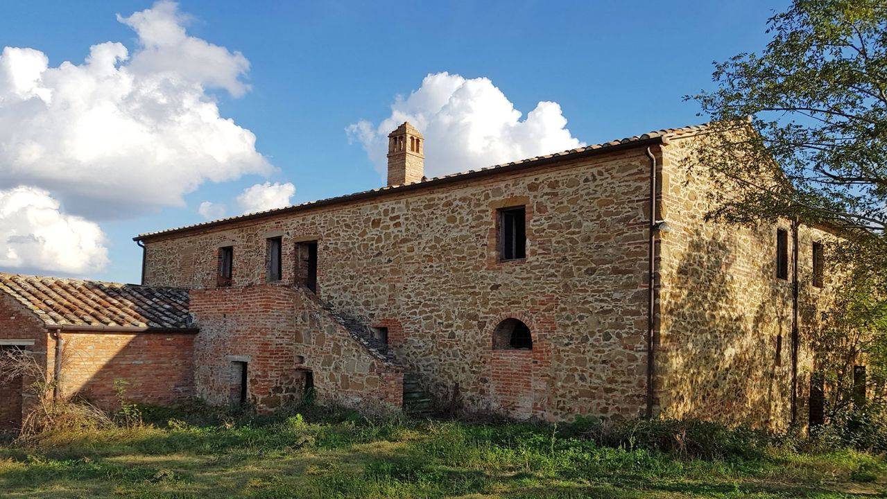 Tuscany, to be restored farmhouse for sale close to Siena. The main building houses wine cellars. Property land in landscaped setting.
