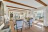 Living room with a high end fireplace, french doors, beam ceiling, and light wood finished floors