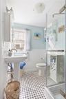 Bathroom featuring toilet, a stall shower, wainscoting, and tile patterned floors