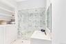 Full bathroom with vanity, a marble finish shower, and light marble finish flooring