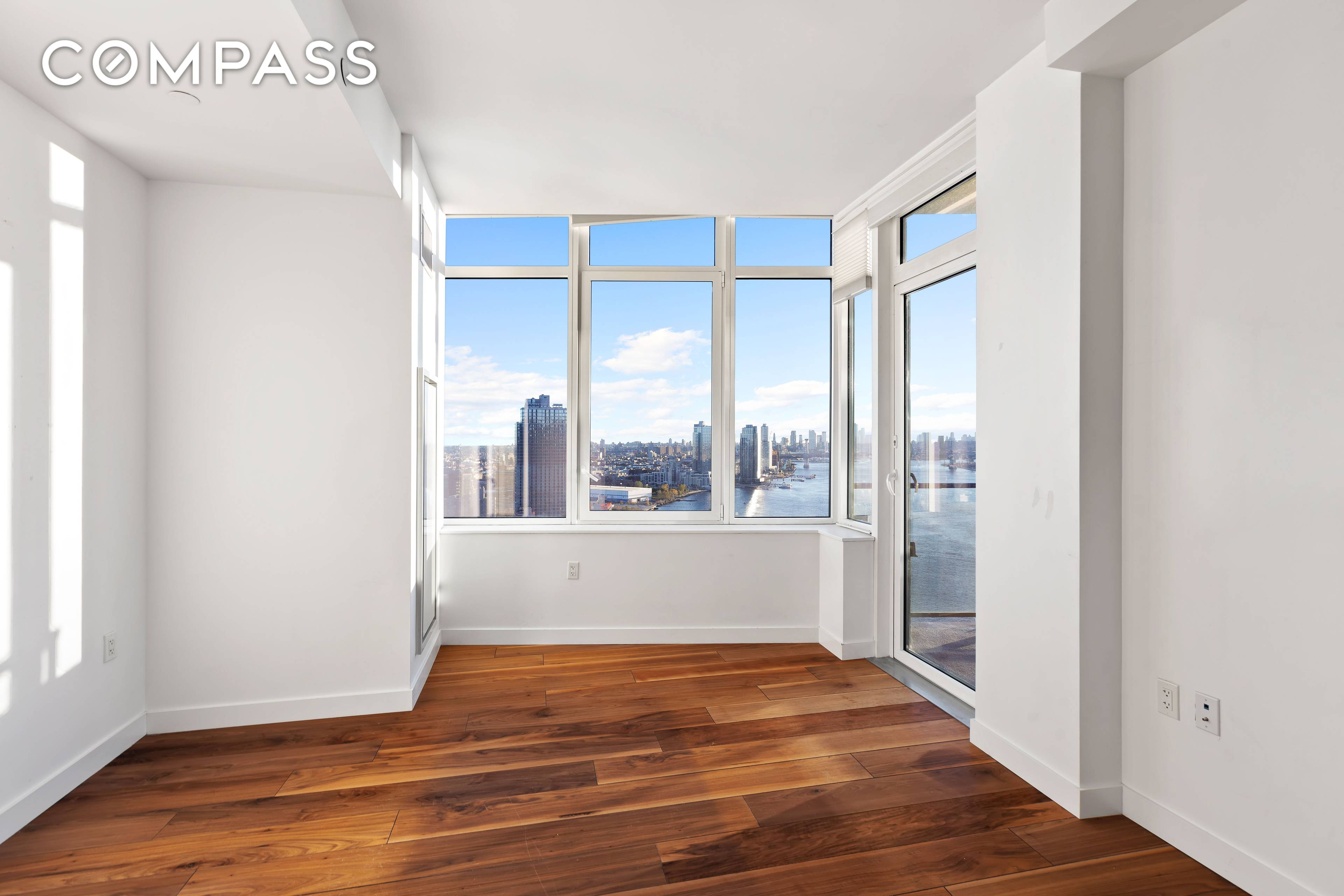 Panoramic views of the East River and Manhattan from your private balcony located on the 32nd floor at The Greenpoint condominium.