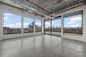 Unfurnished room with finished concrete flooring, plenty of natural light, and a skyline view