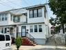 Two-story white siding exterior with contrasting black window frames