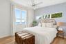 Bedroom featuring wallpapered walls, a water view, an accent wall, a ceiling fan, and light wood-type flooring