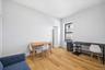1st Floor Apartment living room features light wood flooring and white walls, creating a bright and open atmosphere