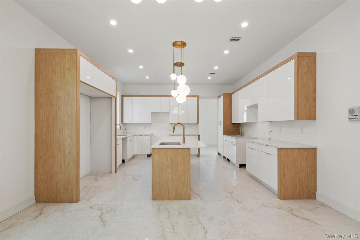 Kitchen featuring white cabinetry, a center island with sink, hanging light fixtures, modern cabinets, and recessed lighting