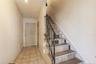 Staircase with tile patterned floors and wood walls