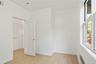 Unfurnished room with healthy amount of natural light, light wood-style flooring, and radiator