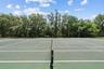 Community tennis court with peaceful natural backdrop.