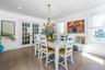 Dining area with french doors, a chandelier, ornamental molding, and wood finished floors
