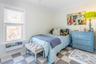 Bedroom featuring tile patterned floors, ceiling fan, and ornamental molding