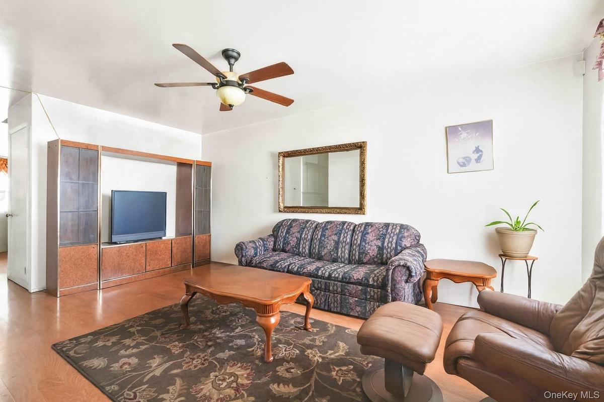 Living area featuring wood finished floors and ceiling fan