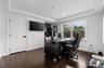 Office area with crown molding, dark wood-type flooring, and a raised ceiling