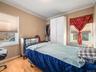 Bedroom featuring crown molding, light wood finished floors, radiator heating unit, and a closet