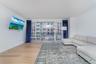 Living room with light wood-type flooring and floor to ceiling windows