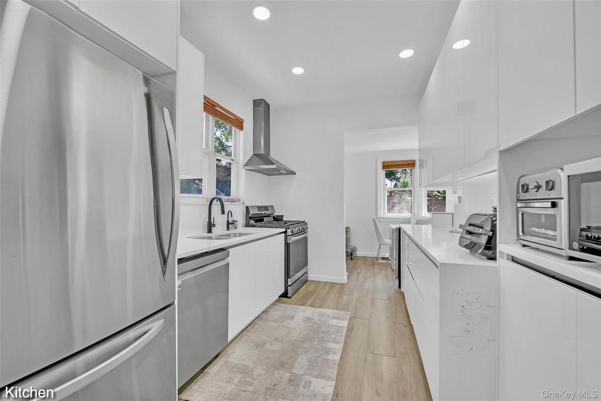 Bright kitchen with light wood-finish flooring and recessed lighting