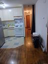 Kitchen with light countertops, white cabinets, gas range gas stove, freestanding refrigerator, and light wood finished floors