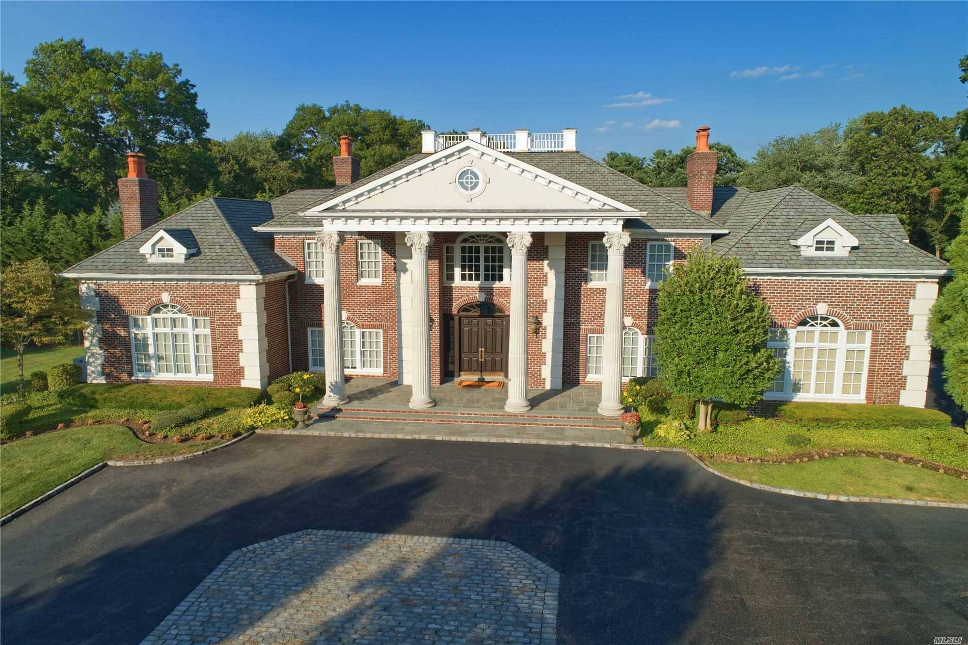 Magnificent Georgian brick colonial manor set beautifully within this private gated community in Old Westbury.
