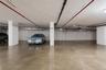 2 Dedicated parking spaces within a subterranean garage, featuring polished concrete flooring and overhead utility lines