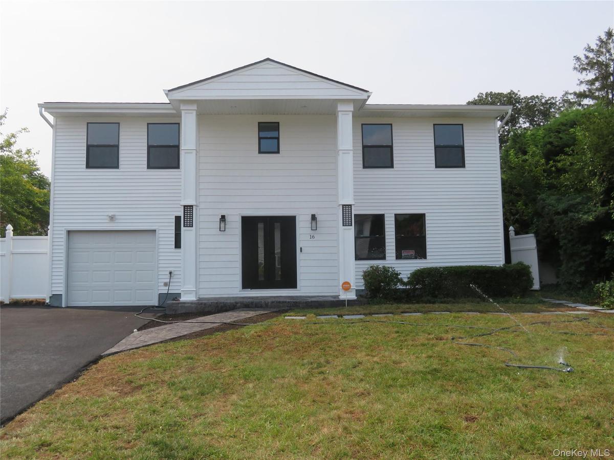 Two-story residence featuring white siding, a prominent columned entry, and a one-car garage