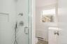 Bathroom with baseboard heating, a shower stall, toilet, and vanity