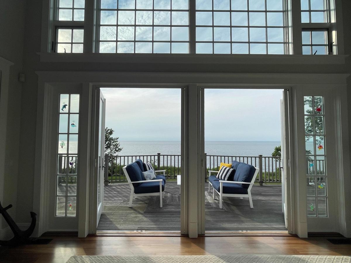 Doorway featuring a water view, wood-type flooring, and a high ceiling
