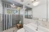 Bathroom featuring tile walls, visible vents, a shower stall, and toilet