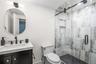 Full bath featuring vanity and a marble finish shower