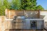 View of patio with area for grilling, wine cooler, and a wooden deck