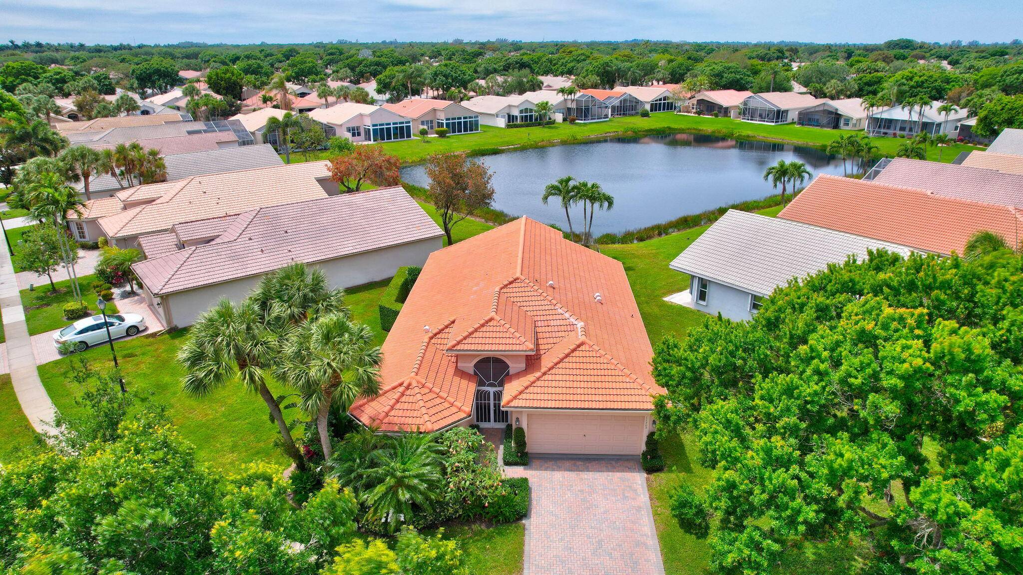 Indulge in the charm of this exquisite three bedroom home, boasting picturesque vistas of a serene lake, complemented by heated pool and spa, lush landscaping and screened covered lanai, a ...