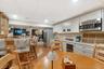 Kitchen featuring white cabinetry, beverage cooler, stainless steel appliances, glass insert cabinets, and light wood-style flooring