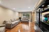 Spacious living area featuring warm wood-finish flooring, recessed lighting, and crown molding
