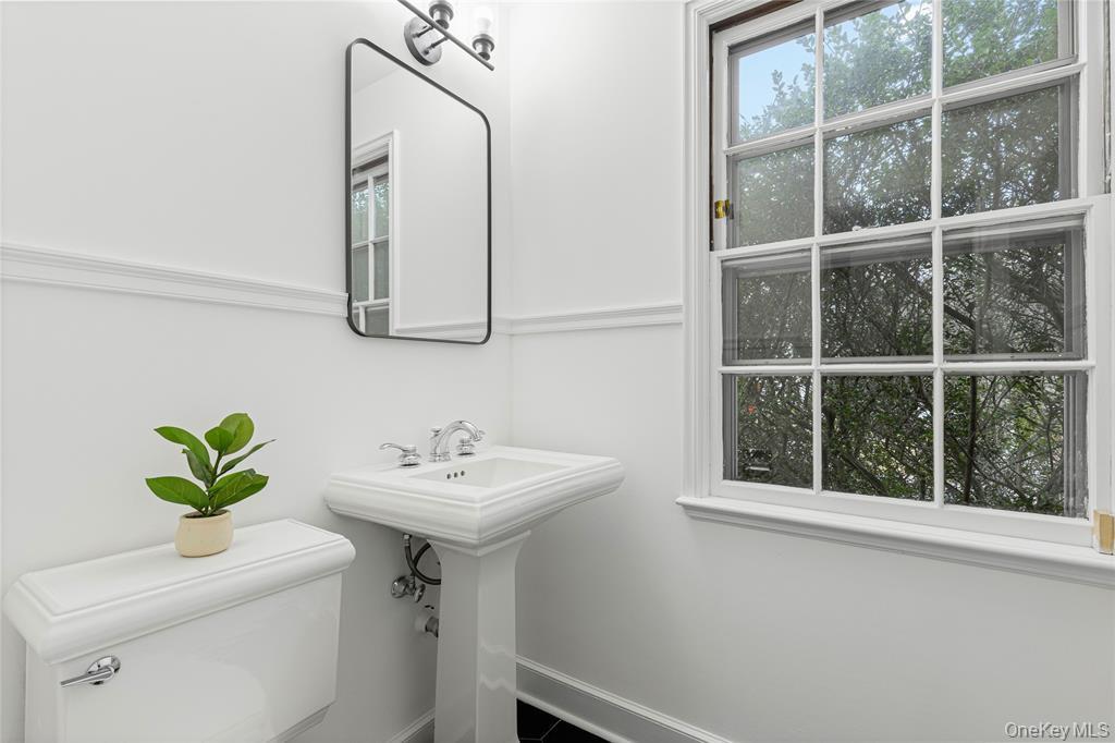 Bathroom with toilet, a sink, and baseboards