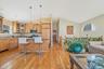 Kitchen with glass insert cabinets, light wood finished floors, open floor plan, a kitchen bar, and pendant lighting