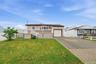 Welcoming front elevation featuring a raised ranch design with composite decking, white railings, and an attached garage